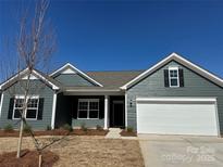 Charming one-story home featuring a two-car garage, gray siding, and classic black shutters at 6327 Honor Ave, Midland, NC 28107