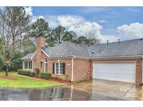 Brick ranch home with attached garage and landscaped yard at 8355 Olde Troon Dr, Charlotte, NC 28277