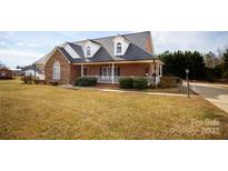 Brick ranch home with stone accents, a large front porch, and a well-manicured lawn at 1270 Mirror Lake Rd, Lincolnton, NC 28092