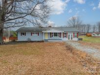 Charming single-story home with light blue siding and a red trimmed porch and shutters at 1486 Amity Church Rd, Denver, NC 28037