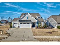 Beautiful two-story home with three-car garage and landscaped yard at 16303 Cozy Cove Rd, Charlotte, NC 28278