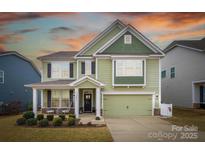 Two-story house with green siding, a two-car garage, and landscaping at 3836 Lake Breeze Dr, Sherrills Ford, NC 28673