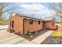 Charming brick home featuring a manicured yard and a welcoming entrance with accessible ramp at 407 Thomas St, Marshville, NC 28103