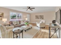Comfortable living room with a ceiling fan, plush seating, and wood-look flooring at 407 Thomas St, Marshville, NC 28103