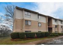 Brick condo building with landscaping and water view at 4902 Spring Lake Dr # E, Charlotte, NC 28212