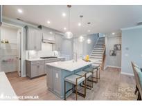 Modern kitchen with island, stainless steel appliances, and light gray cabinets at 9842 Quercus Ln, Huntersville, NC 28078