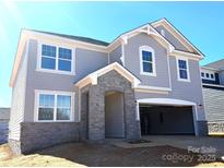 Beautiful two-story home with stone accents, attached garage, and manicured landscaping at 9934 Cask Way, Huntersville, NC 28078