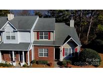 An aerial view of a charming townhouse showing brick accents and a well-maintained roof at 10904 Pimlico Dr, Charlotte, NC 28273