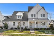 Two-story farmhouse with white siding, gray roof, and landscaped lawn at 13308 Oak Farm Ln, Huntersville, NC 28078