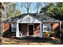 Brick ranch house with a covered porch and mature trees at 1814 Logie Ave, Charlotte, NC 28205