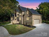 Two-story brick home with a three-car garage and landscaped lawn at 209 E Glenview Dr, Salisbury, NC 28147