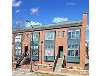 Brick townhomes with stoops, large windows, and painted window frames under a partly cloudy, blue sky at 544 New Bern Station Ct, Charlotte, NC 28209