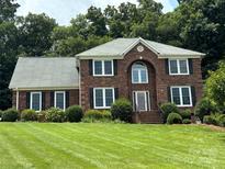 Brick house with gray roof and manicured lawn at 5972 Rathlin Nw Ct, Concord, NC 28027