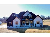 Two-story home with white and black exterior, and landscaping at 1008 Harrogate Dr, Bessemer City, NC 28016