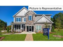 Two-story home with stone and gray siding, landscaped yard at 1023 Merganser Way, Indian Trail, NC 28079
