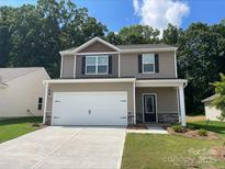 Two-story house with neutral siding, white garage door, and landscaping at 3259 Maple Ridge Dr, Gastonia, NC 28052