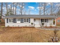 Brick ranch house with shutters, landscaping, and a walkway at 4630 Dawnwood Dr, Charlotte, NC 28212