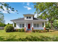 Charming two-story home with a red door and a cozy front porch at 6037 Pleasant Grove Rd, Charlotte, NC 28216