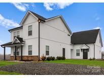 This is the exterior elevation of a two-story home with white siding and a dark roof at 6101 Bunn Simpson Rd, Marshville, NC 28103