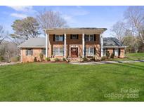 Stately two-story brick home with large white columns and manicured front lawn at 107 Cambridge Rd, Huntersville, NC 28078