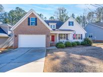 Brick and white charming house with a red door, two-car garage, and manicured lawn at 1361 Colwick Ln, Rock Hill, SC 29732