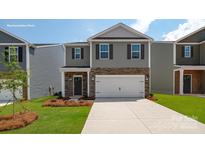 Charming two-story home featuring gray siding, stone accents, a two-car garage, and a well-maintained front yard at 1427 5Th Street Ne Dr, Hickory, NC 28601