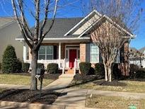 Charming single-story home featuring a welcoming front porch, red front door and well-maintained landscaping at 18211 Ebenezer Dr, Cornelius, NC 28031