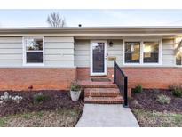 Brick ranch house with a welcoming front porch and landscaping at 1908 Starbrook Dr, Charlotte, NC 28210