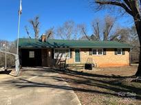 Ranch home with green roof and brick facade, featuring a spacious yard at 2349 Flint Hill Church Rd, Shelby, NC 28152