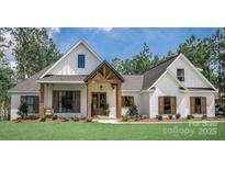 White farmhouse exterior with a welcoming front porch and landscaping at 304 Tradition Dr, Mount Gilead, NC 27306