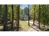 Two-story house nestled in a wooded area with a paved driveway at 305 Saddlewood Dr, Gastonia, NC 28056