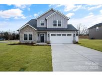 Two-story house with gray siding, stone accents, and a white garage door at 3070 Swallowtail Ln, Kannapolis, NC 28027