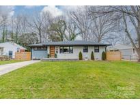 Charming ranch home with gray and white brick exterior and landscaped yard at 531 Manhasset Rd, Charlotte, NC 28209
