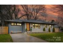 Charming, renovated ranch home with a modern door, gray and white brick exterior and manicured front yard at 531 Manhasset Rd, Charlotte, NC 28209