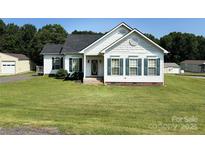 Charming single-story home featuring a well-manicured front yard, red door, and classic shutters at 6328 W Nc 10 Hwy, Hickory, NC 28602