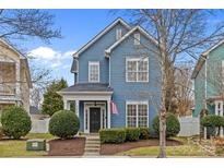 Charming two-story home featuring a blue exterior, well-manicured landscaping, and a welcoming front porch at 6823 Dunton St, Huntersville, NC 28078