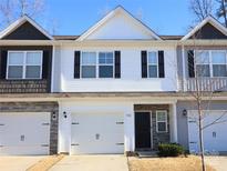 Charming townhome featuring a stone veneer, white garage door, black shutters, and well-maintained front lawn at 7132 Somerford Rd, Charlotte, NC 28215