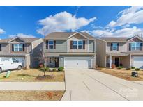 Two-story house with gray siding, white garage door, and landscaping at 9353 Creedmore Hills Dr, Charlotte, NC 28214
