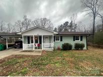 Ranch home features a covered porch, carport and a spacious yard at 102 Hickory St, Locust, NC 28097