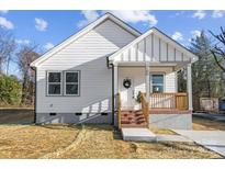 Charming white house with brick steps, wooden porch railing, and landscaping at 109 E Broad St, Salisbury, NC 28144