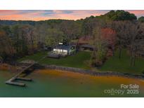 Stunning lakefront home with private dock, lush lawn, and mature trees provides exceptional outdoor living and scenic views at 125 Chestnut Tree Rd, Mooresville, NC 28117