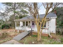 Charming white cottage with a porch, ramp, and landscaping at 160 Brookwood Ne Ave, Concord, NC 28025