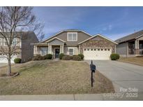 Charming home featuring a manicured lawn, stone accents, and an attached two car garage at 2001 Yellow Daisy Dr, Matthews, NC 28104