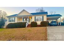 One-story house with front porch, carport and landscaped yard at 603 Helms Dr, Lowell, NC 28098