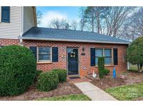 Charming brick home featuring a black front door with wreath, trimmed hedges, and well-maintained landscaping at 749 21St Ne Ave, Hickory, NC 28601