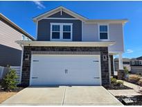 Two-story home with gray and white siding, stone accents, and a two-car garage at 800 Parkette St, Concord, NC 28027