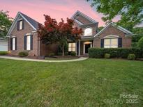 Brick home with landscaping, a walkway, and a spacious lawn at 8100 Avanti Dr, Waxhaw, NC 28173