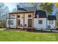 Charming white farmhouse with a covered porch and landscaped lawn at 910 S College Ave, Newton, NC 28658