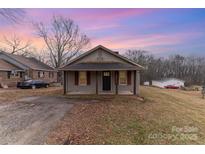 One-story house with a front porch, red shutters, and a spacious yard at 107 Mcginnis St, Kings Mountain, NC 28086