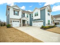 A beautiful two-story home features a two-car garage, stone accents and a wide driveway at 13020 Hindcross Dr, Huntersville, NC 28078